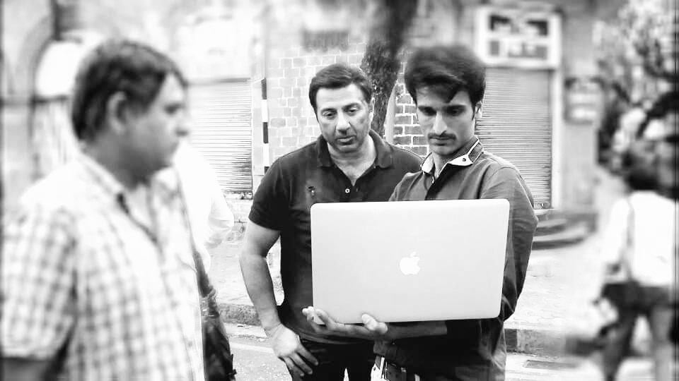 Street location: DIT reviewing footage with crew members during production